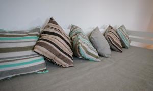 a row of pillows sitting on a bed at Cabaña 1920 - frente a viñedo in San Rafael