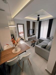 een woonkamer met een tafel en een bank bij MK Boutique Apartment Perea in Perea