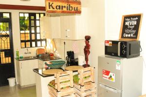 Wakanda@HeArt Stays في Kakamega: مطبخ مع ثلاجة وطاولة مع كراسي