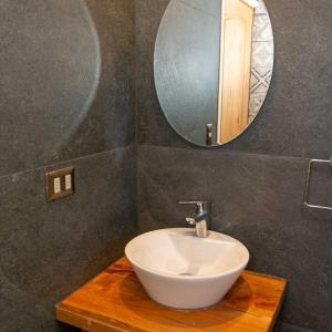 een badkamer met een witte wastafel en een spiegel bij Los Cantos del Agua in Curacautín