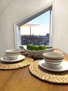 a table with bowls and plates on a table with a window at Downtown Sunny Penthouse ! in Denver