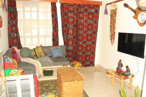 a living room with a couch and a flat screen tv at Wakanda@HeArt Stays in Kakamega