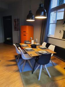 a dining room table with white chairs around it at Loft mit privater Sauna in Heidelberg