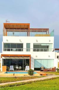 a large white house with a lot of windows at Solymar Beach House - Paracas in Paracas