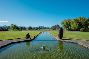a fountain in a park with a dog in the water at Battys Road Lodge in Blenheim