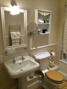 a bathroom with a sink and a toilet and a mirror at Trearddur Bay Hotel in Trearddur