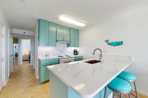 a kitchen with blue cabinets and a white counter top at Tradewinds 601 in Orange Beach