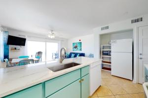 a kitchen with a sink and a white refrigerator at Tradewinds 601 in Orange Beach