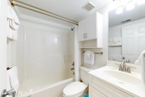a white bathroom with a sink and a toilet at Tradewinds 601 in Orange Beach
