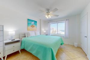 a white bedroom with a bed and a window at Tradewinds 601 in Orange Beach