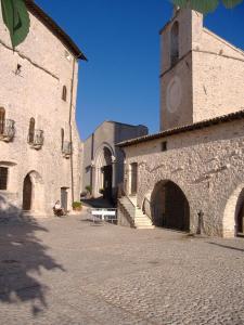 un gran edificio de piedra con una torre de reloj en Umbria Valnerina in Noble Residence near Spoleto Apartment x 4-6 persons en SantʼAnatolia di Narco