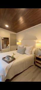 a bedroom with a white bed with a tray on it at La Canaria Casa de Campo in Colonia Caroya