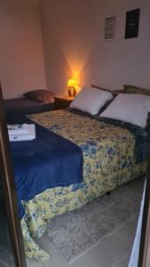 sypialnia z 2 łóżkami i stołem z lampką w obiekcie Cananeia Suítes w mieście Cananéia