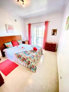 ein Schlafzimmer mit einem großen Bett mit roten Vorhängen in der Unterkunft Flamingos Apartment with 2 swimming pool com check in e check out ao domingo em julho e agosto in Albufeira