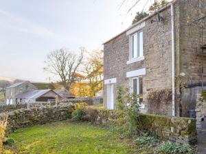 una antigua casa de ladrillo con una pared de piedra en Heckberry Cottage en Burtree Ford