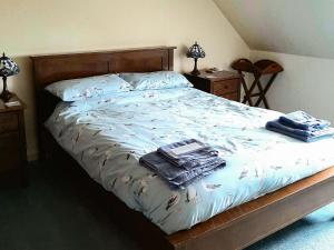 a bedroom with a bed with clothes on it at Shore Cottage in Rockfield