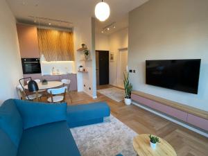 a living room with a blue couch and a dining room at Floral Inn in Pristina