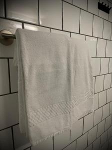biały ręcznik wiszący na wieszaku na ręczniki w łazience w obiekcie Gåsen Out w mieście Burgsvik