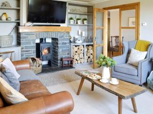 a living room with a couch and a fireplace at Maes Y Bryn Farmhouse in Llanwrda