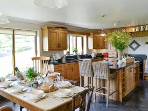 una cocina con una mesa de madera con platos. en Maes Y Bryn Farmhouse en Llanwrda
