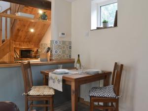 een keuken met een houten tafel en 2 stoelen bij Fourwinds in Farlow