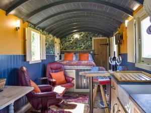una camera ferroviaria con letto, tavolo e sedie di Foxglove a Woolland
