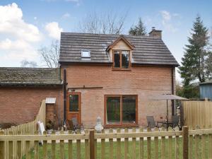 een stenen huis met een hek ervoor bij Fourwinds in Farlow