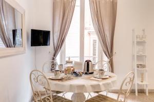 ローマにあるCasa Dolce Casaの窓付きの客室で、白いテーブルと椅子が備わります。