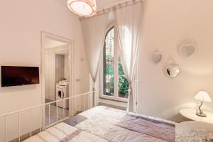 a white bedroom with a bed and a window at Casa Dolce Casa in Rome