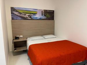 a bedroom with a bed with a painting on the wall at HOTEL G22 COLECTION in Florencia