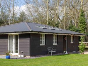 a small house with a black roof at Breckland Cottage in Hockwold cum Wilton