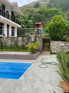 a swimming pool in front of a building with a house at Casa del lago garagoa Boyaca in Garagoa