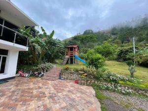 una casa con un camino de ladrillo que conduce a un jardín en Casa del lago garagoa Boyaca, en Garagoa