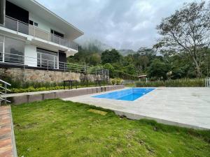 a swimming pool in front of a house at Casa del lago garagoa Boyaca in Garagoa