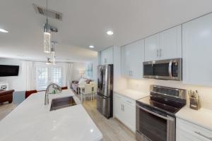 a kitchen with white cabinets and stainless steel appliances at Summer Lake Townhomes 1 in Destin