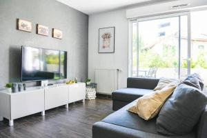uma sala de estar com um sofá e uma televisão de ecrã plano em Le Capé-Grand appartement avec terrasse et jacuzzi em Marselha