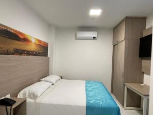 a small bedroom with a bed and a tv at HOTEL G22 COLECTION in Florencia