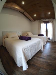 1 dormitorio con 2 camas con sábanas blancas y ventana en EL Rincón de Lola, en Carboneras de Guadazaón