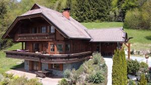 a large wooden house with a roof at Ferienhaus Kraxlhütte Kärnten in Velden am Wörthersee