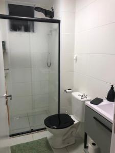 ein Bad mit einer Dusche und einem WC mit einem schwarzen Sitz in der Unterkunft Apartamento encantandor-perto centro e shopping in Poços de Caldas