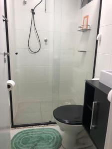 ein Bad mit einer Dusche, einem WC und einem Waschbecken in der Unterkunft Apartamento encantandor-perto centro e shopping in Poços de Caldas