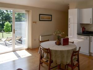 a kitchen and dining room with a table and a kitchen with a window at Wellys Wallow in Saint Kew