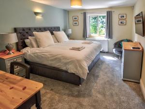 a bedroom with a large bed and a table at Hadrians Garden Villa in Bardon Mill