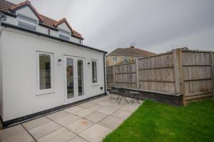 a patio with a bench next to a fence at Hideaway Cottage in Bristol