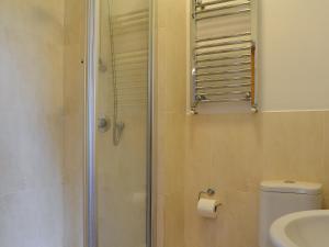 a bathroom with a shower with a toilet and a sink at Jasmine Cottage in Knitsley