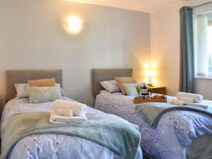 two beds sitting next to each other in a bedroom at Camellia Cottage in Saint Ewe