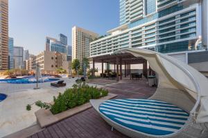 un complexe avec une piscine, une chaise et un parasol dans l'établissement Dubai Marina - 5 bedroom, resort feel, great Amenities, à Dubaï