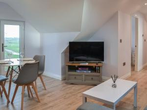 a living room with a tv and a table with chairs at Falabella Suite - Uk41829 in Tickton