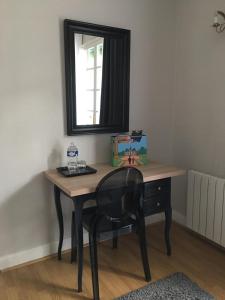 escritorio con silla en una habitación con espejo en La Tour de Saint Cyr, en Saint-Cyr-sur-Loire