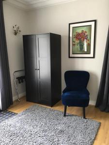 um quarto com uma cadeira azul e um armário em La Tour de Saint Cyr em Saint-Cyr-sur-Loire